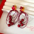 Detail view of retro red and yellow acrylic beaded tassel earrings in a jewelry box - Red Geometric Tassel Style (HE27925)