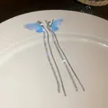 Detailed macro view of blue mesh butterfly wing earrings with long sparkling tassels - Long Tassel Butterfly Design / Blue