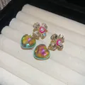 Elegant vintage crystal heart earrings with floral accents on beige jewelry tray - Silver Earring Post Style / Gold Green Pink Combination