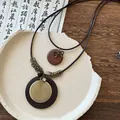 Gros plan d'un long collier de style Zen néo-chinois avec un pendentif en métal doré - Collier Nœud Double Pendentif (6#)