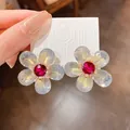 Primer plano de pendientes de flores con cristales rojos sobre cartón. - Estilo de Flor (HE9677) / Gris