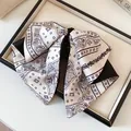 Close-up detail of a vintage paisley print bow hair clip on a linen display tray - Hair Claw / White