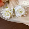 Dettaglio macro di orecchini a rosa in tessuto bianco con gocce di rugiada - Ago d'argento / Giallo chiaro