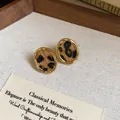 Dettaglio di orecchini ovali dorati vintage con trama leopardata di tendenza - Stile Ovale Maculato (5944763480743)