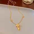 Gedetailleerde weergave van een vergulde drakenhanger ketting op een minimalistisch dienblad - Chinese Draak Vorm (16# Ketting-Goud)