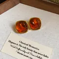 Dettaglio di orecchini a perno quadrati vintage in resina ambra con eleganti bordi dorati - Stile Quadrato Ambra (5944763480737)