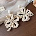 Close-up of handmade raffia woven flower earrings with intricate texture - Flower Shape / White
