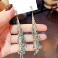 Detail view of elegant tassel earrings with blue glass teardrops and silver chains. - Silver Earring Post - Silver - Tassel