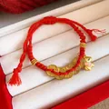 Gros plan d'un bracelet en corde tressée rouge avec poney doré et breloques pièces - 7# Bracelet-Or-Rouge-Pièces (Pendentif Cochon d'Or)
