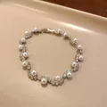 Elegant silver-toned bracelet with pearls and sparkling rhinestones on a warm background - Bracelet / Silver