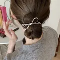 Detailed view of a silver bow hair clip on a brunette bun for a Korean aesthetic style - 5# Duckbill Clip - Silver Bow