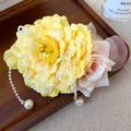Close-up of yellow and pink fabric flower hair clip with elegant pearl tassels. - Yellow Peony Tassel Style