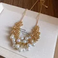 Detail shot of French vintage necklace featuring clustered pearls and gold beads - Gold-White