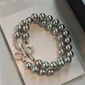 Detailed macro shot of a double-strand grey pearl bracelet with a sparkling crystal bow. - Style 5 Bracelet / Silver-Grey