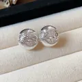 Vue rapprochée de clips d'oreilles sphériques texturés au fini argenté dans un écrin à bijoux - Sphère / Argent