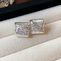 Détail de boucles d'oreilles géométriques en argent avec une surface texturée. - Carré / Argent