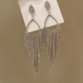 Detailed macro view of sparkling rhinestone waterdrop tassel earrings with fringe design - Silver (Silver Pin)