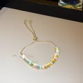 Close-up of adjustable gold-tone bracelet with colorful rectangular cubic zirconia - Multicolor Rectangular