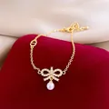 Elegant gold-tone bracelet featuring a zircon-studded bow and a dangling pearl pendant - 32# Bracelet (Bowknot Pearl CD Tag)
