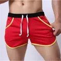 Detail view of men's red breathable mesh sports shorts featuring yellow trim and drawstring - M / Red