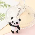 Detailed view of a cute cartoon panda keychain with a waving hand and red heart detail - Heart Panda