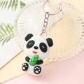 Close-up of a cute 3D cartoon panda keychain pendant holding a green leaf in soft silicone - Panda Holding Bamboo