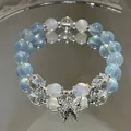 Elegante pulsera de cuentas azules etéreas con dije de mariposa de cristal brillante - Mariposa azul bruma