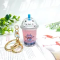 Cute cherry blossom cat milk tea cup keychain with pink liquid and blue pearls - Regular Cat Purple