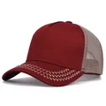 Close-up detail of a retro burgundy trucker hat featuring mesh back and zigzag brim stitching. - Burgundy