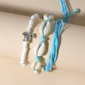 Set aus weißen Perlen-Schildkröten- und blau geflochtenen Kaurimuschel-Armbändern - 3-teiliges Set / Seeblau