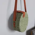 Detailansicht einer salbeigrünen runden Strohtasche mit elegantem braunem Lederriemen - Grün
