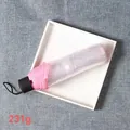 Leichter rosa Taschenschirm mit 231g Gewicht auf einem minimalistischen weißen Tablett - Manueller transparenter rosa Regenschirm