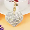 Sparkling iridescent rhinestone heart keychain with white tassel and gold bell pendant - Gold Tone + White Base With AB Rhinestones