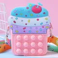 Dettaglio di una borsa pop-it in silicone a forma di cupcake con tracolla colorata - Rosa