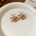 Vintage flower-shaped earrings with imitation pearls and gold plating in brown tones. - Brown