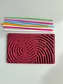 Vista dall'alto di tavola sensoriale in silicone con bastoncini colorati su sfondo bianco - Borgogna