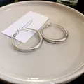 Elegante minimalistische silberne polierte dicke Creolen auf einem weißen Keramikteller - 20# Silber (Klein)