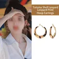 Detail of tortoiseshell resin hoop earrings with leopard print and gold accents - Round Hoop / Coffee Leopard