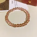 Nahaufnahme eines transparenten rosa Glasperlenarmbands auf minimalistischem Grund - Kristall-Minimalismus-Stil (26#) / Rosa