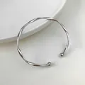 Elegante bracciale rigido minimalista in metallo argento con design geometrico a spirale - Bracciale Rigido Geometrico Intrecciato (HB637) / Argento
