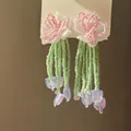 Detailed view of hand-beaded flower tassel earrings with pink and green accents. - Style 7 (Silver Post)