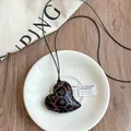 Retro hartvormige ketting met luipaardprint gepresenteerd op een wit schoteltje - Geometrische Hart Hanger (10#)