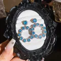 Elegante blauwe edelsteen halo oorringen gepresenteerd in een zwarte vintage lijst - Stijl 55 (HE32568)