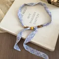 Collana vintage in tessuto scozzese blu con perline su sfondo di un libro - Collana Scarf a Quadri Blu e Bianco (Perle) / Blu