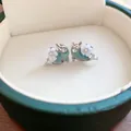 Elegant silver-toned dolphin stud earrings with flower and rhinestone details in a green box - Dolphin Floral Style (HE13225)