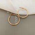 Primo piano dettagliato di eleganti orecchini a cerchio dorati su sfondo grigio minimalista - Perno in Argento Cerchio Stile Occidentale Oro (58#) / 3cm / Oro