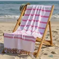 Absorbent pink striped cotton beach towel with handmade tassels on a wooden beach chair. - 100*180CM / Pink Fine Stripe