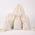 Collection of natural cream cotton drawstring gift bags in various tiered sizes - 9x12cm
