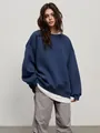 Detail shot of women's oversized navy blue crewneck sweatshirt in a soft fleece fabric. - Dark Blue