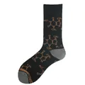 Close-up of black novelty crew socks featuring a tan caffeine molecule pattern design - US 4 / One Size